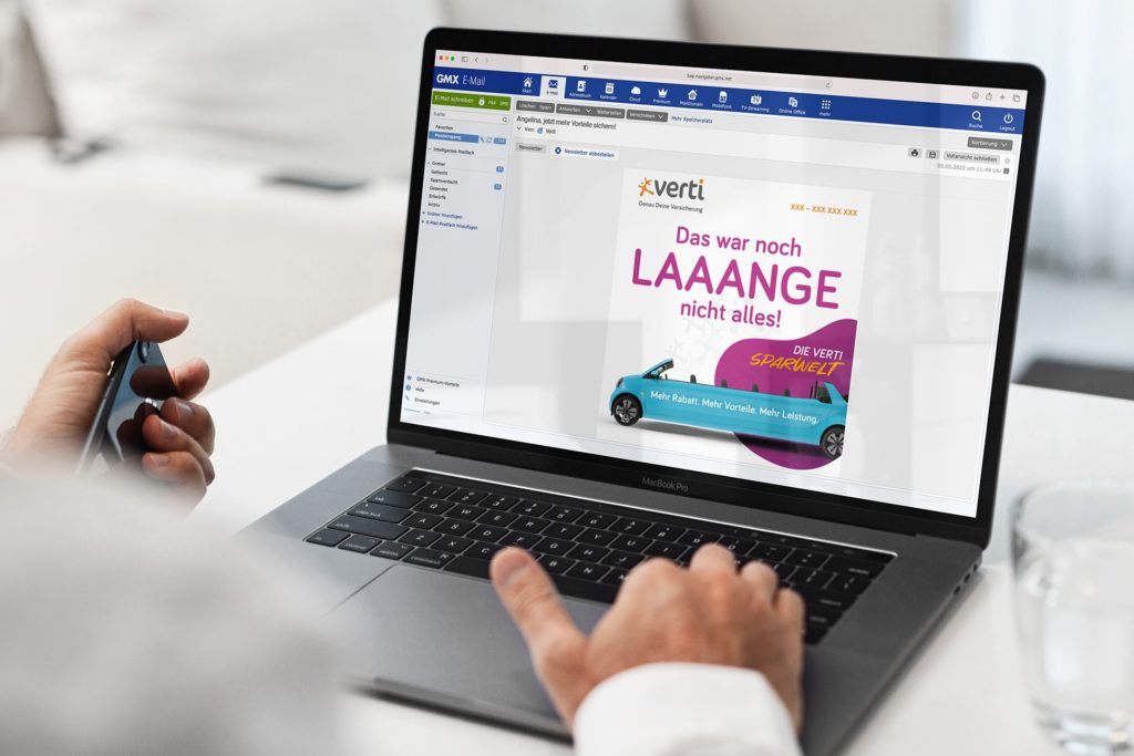 Eine Person sitzt vor einem Laptop, auf dessen Bildschirm eine E-Mail von Verti Versicherungen geöffnet ist. Die Nachricht wirbt mit dem Slogan „Das war noch LAAANGE nicht alles!“ und zeigt ein blaues Auto als visuellen Hingucker.